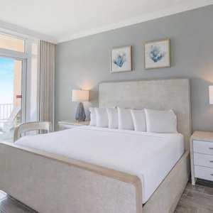 Retreat to the king master suite with cozy bedding and drift off to the sound of the waves from the balcony