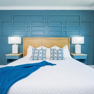 Stylish master bedroom with a plush king bed, decorative pillows, and soothing blue accents for a restful stay