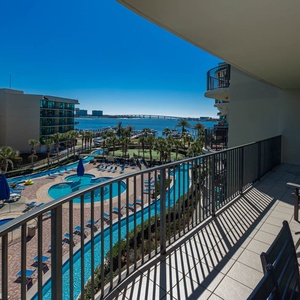 Lounge on the balcony overlooking the refreshing pool, lazy river, stunning bay water, and marina activity