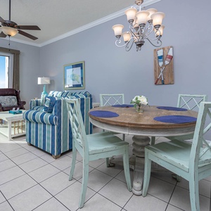 Enjoy meals at the round dining table, while the inviting living area offers comfortable seating and beach views