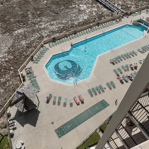 A vibrant pool area features a large swimming pool, sun loungers, and a shaded gazebo, perfect for relaxation and fun