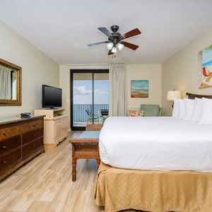 Unwind in the spacious master bedroom with a king bed, stylish decor, and a view of the inviting balcony area