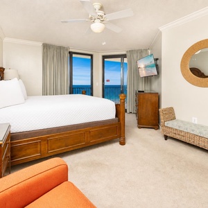 The king bed in the master suite faces glass doors opening to your balcony with calming coastal views