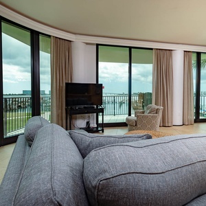 Unwind on the plush sofa while enjoying breathtaking panoramic views of the bay through expansive windows