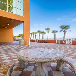 Relax at the beachfront patio with picnic tables, palm trees, and a grill for a perfect outdoor gathering