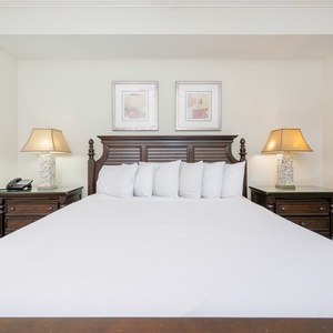 Cozy master bedroom featuring a king bed, elegant lamps, and tasteful artwork for a relaxing retreat