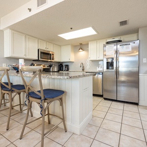Modern kitchen featuring granite countertops, sleek cabinetry, coffee station, and bar seating for a relaxed dining vibe
