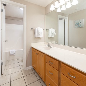 Freshen up in this master bathroom featuring a spacious vanity, ample storage, and a relaxing tub-shower for your comfort