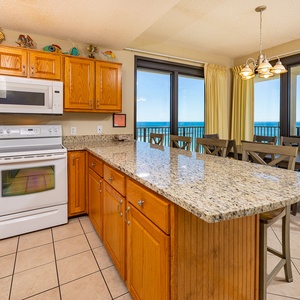 Sunlight glints off granite counters as you prepare meals with cheerful coastal decor nearby in the kitchen