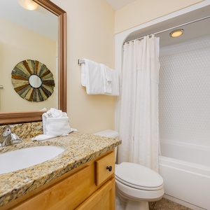Experience convenience in this guest bathroom, featuring ample space and a soothing vibe for freshening up after beach fun