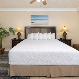 Unwind in the king master suite, where soft bedding invites restful nights and serene views await beyond the doors