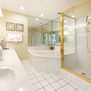 Indulge in the relaxing atmosphere of this master bathroom, featuring a spacious soaking tub and walk-in shower