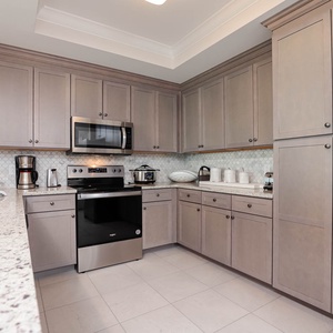Prepare meals in this kitchen with elegant cabinetry, stainless appliances, and stylish backsplash