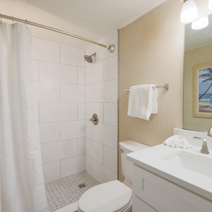 This bathroom features a stylish shower, modern fixtures, and a beach-themed artwork for a refreshing experience
