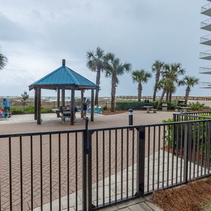 Relax under the gazebo surrounded by palm trees, with lounge chairs nearby for sunbathing and enjoying the fresh gulf air
