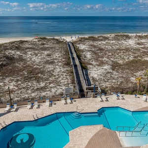 Lounge by the inviting pool area with comfortable seating and easy access to the beach via a scenic boardwalk