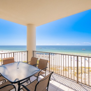 Enjoy marvelous views from the balcony, featuring a glass-top table and comfortable seating overlooking the pristine beach