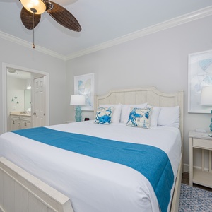 Unwind in the inviting master bedroom featuring a king bed, coastal decor, and soft lighting for a restful escape