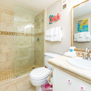 Refresh in the guest bathroom, where the elegant tile shower and plush towels invite moments of relaxation