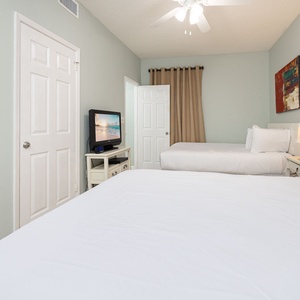 Relax in this comfortable guest room featuring two beds, a TV, and soft lighting for a restful stay