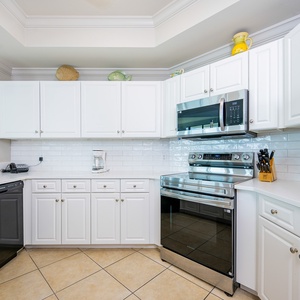 Prepare meals in this kitchen with elegant cabinetry, stainless appliances, and stylish backsplash