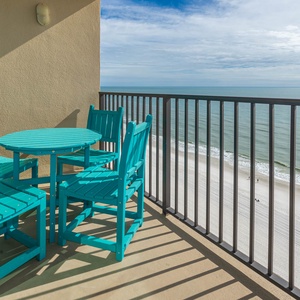 Enjoy a refreshing drink at the turquoise table set on the balcony, overlooking the serene water and shoreline