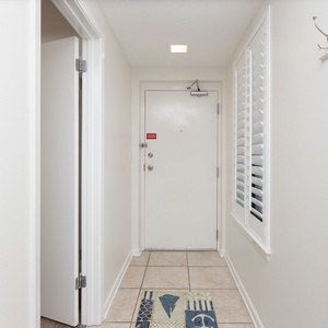 Welcoming entryway featuring a tiled floor, light walls, and a decorative rug, setting a relaxed vacation tone