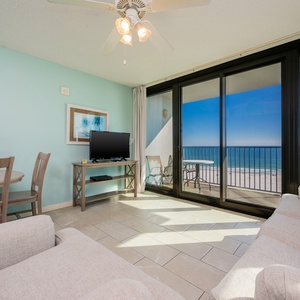 Unwind in the inviting living area with a TV, sofa with queen sleeper, and a view of the beach from your beachfront balcony