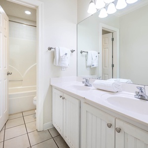 Experience convenience in this master bathroom with dual sinks, ample storage, and a relaxing tub-shower combination