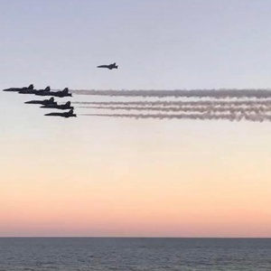 Listen to the blue angel jets streaking across the gulf at sunset, their contrails glowing above the horizon