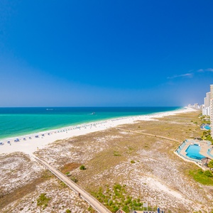 Vibrant beach views stretch along the shoreline, showcasing white sand and inviting turquoise waters from the balcony