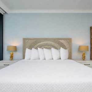 Relaxing master suite featuring a king bed, stylish lamps, and sliding doors that lead to your beachfront balcony