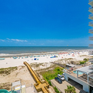 Stunning beachfront view with colorful umbrellas and beachgoers under the clear blue sky
