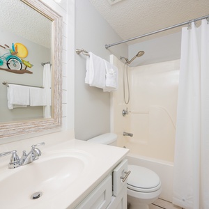 Refresh in this clean guest bathroom featuring a spacious vanity, fluffy towels, and a charming bicycle decor accent