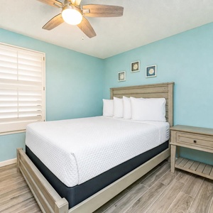 Blue walls surround the guest suite with a cozy queen bed and soft pillow comfort awaiting you