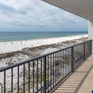 Enjoy breathtaking beachfront views from this balcony with blue chairs, perfect for relaxation and soaking in the scenery
