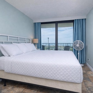 The master suite features a king bed and offers a stunning beachfront view through large sliding glass doors
