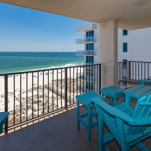 Relax on the balcony in vibrant seating, enjoying expansive views of the shoreline and tranquil waters