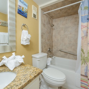 Indulge in a refreshing shower in the guest bath amidst beach decor and soft towels, setting the tone for your day