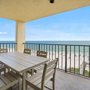 Spacious beachfront balcony offering a direct view of the beach and gentle waves