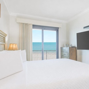 Enjoy a peaceful night's sleep with serene coastal views and soft lighting enhancing the master suite