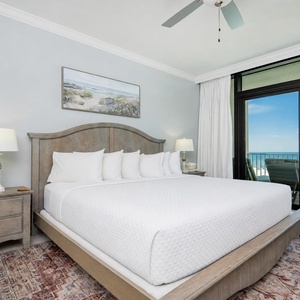 Elegant king master suite with soft pillows and beachfront balcony access