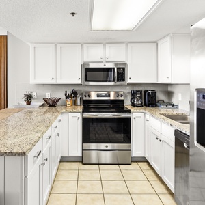 Bright kitchen features granite countertops, stainless appliances, and a breakfast bar with seating for casual dining