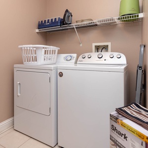 The laundry area features a washer and dryer, a basket for convenience, and shelving for storage, making chores easy