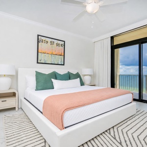 Inviting master suite featuring a king bed, stylish decor, and beachfront balcony access