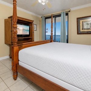 Relax in the master bedroom featuring a four-poster king bed, a TV for entertainment, and a view that enhances your stay