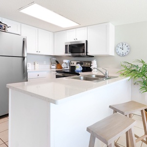 Prepare meals in this inviting kitchen featuring stainless appliances, a breakfast bar, and a modern design