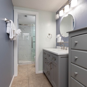 Experience the stylish master bath featuring a spacious vanity, modern fixtures, and a glass-enclosed walk-in shower