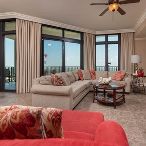 The living area features a plush sofa, vibrant red accents, and a large TV, perfect for relaxation with a state park view