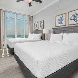 Wake to a breathtaking sunrise in this queen guest suite with two cozy beds and expansive views from the windows